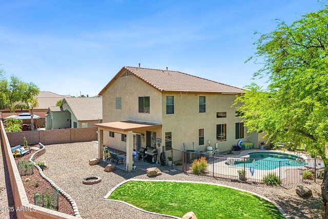 back of property featuring stucco siding, a fenced in pool, a patio, and a fenced backyard