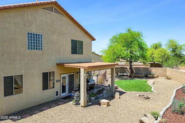 back of property with stucco siding, a fenced backyard, and a patio area