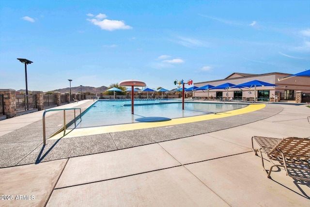pool with a patio and fence