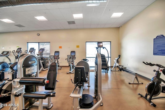 workout area featuring visible vents, a paneled ceiling, and baseboards
