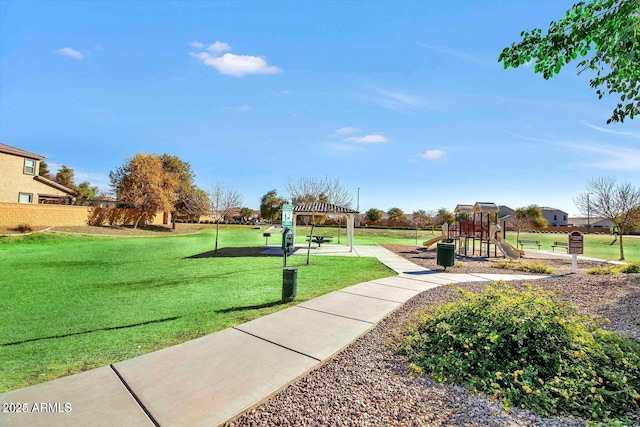 view of community featuring a lawn, playground community, and a pergola