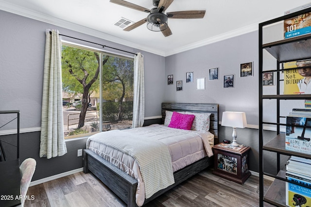 bedroom featuring baseboards, visible vents, ornamental molding, and wood finished floors