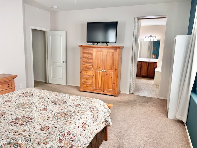 bedroom featuring connected bathroom and light colored carpet