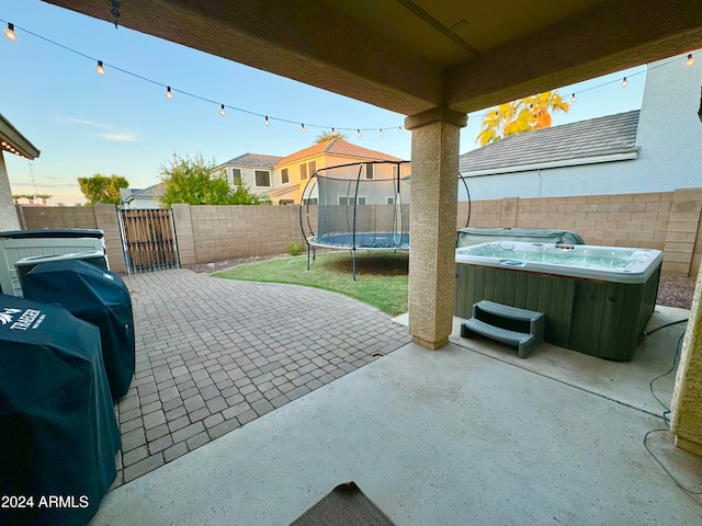 view of patio featuring a hot tub and a trampoline