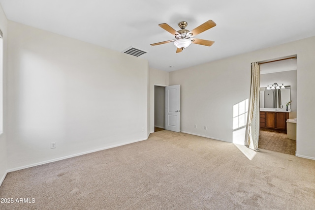 unfurnished bedroom with ceiling fan, connected bathroom, and light carpet