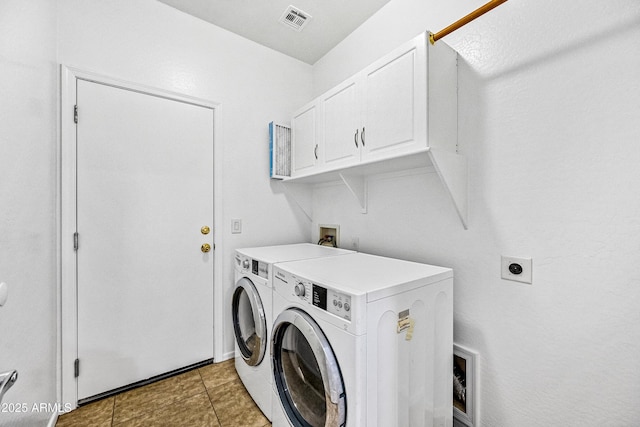 washroom featuring cabinets, separate washer and dryer, and light tile patterned floors