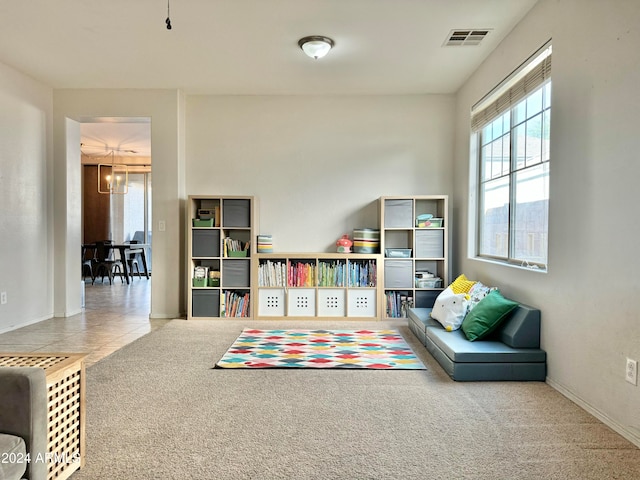 game room featuring a chandelier and carpet