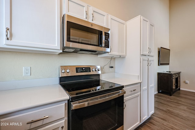 kitchen featuring white cabinets, dark hardwood / wood-style flooring, and appliances with stainless steel finishes