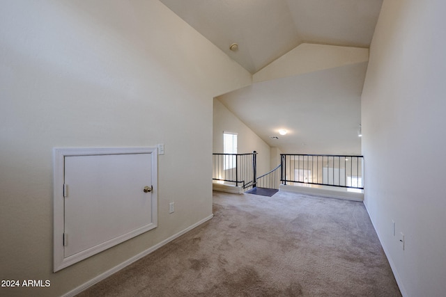 carpeted empty room featuring lofted ceiling