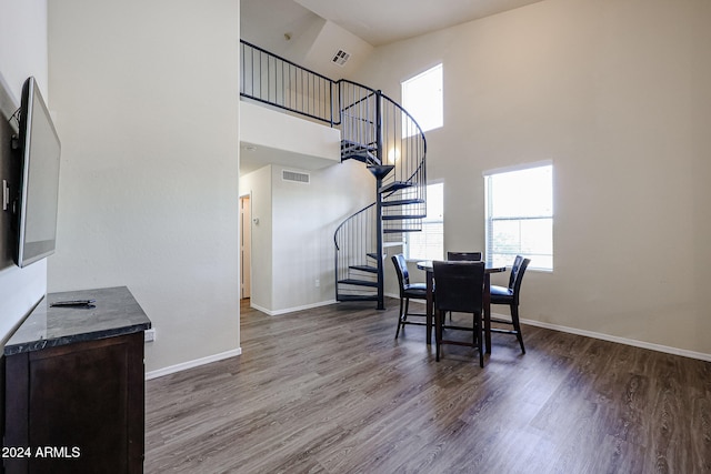 dining space featuring hardwood / wood-style floors and a high ceiling