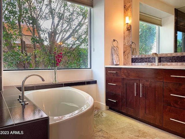 10068 E Turquoise Ave, Scottsdale, AZ 85258 - bathroom featuring a freestanding bath, vanity, and stone tile floors