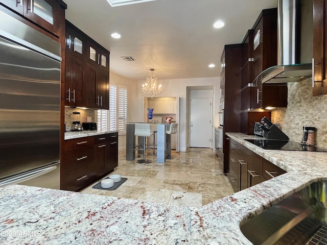 10068 E Turquoise Ave, Scottsdale, AZ 85258 - kitchen featuring an inviting chandelier, black electric stovetop, built in fridge, glass insert cabinets, and wall chimney exhaust hood