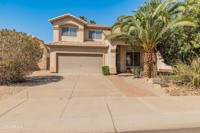 mediterranean / spanish-style home with stucco siding, a tile roof, a garage, and concrete driveway