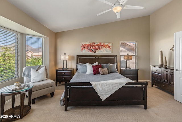 bedroom with baseboards, lofted ceiling, ceiling fan, and light carpet