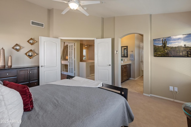 bedroom featuring high vaulted ceiling, visible vents, baseboards, light carpet, and arched walkways
