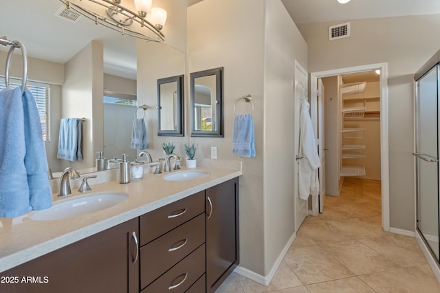 full bath featuring visible vents, a sink, a stall shower, and double vanity