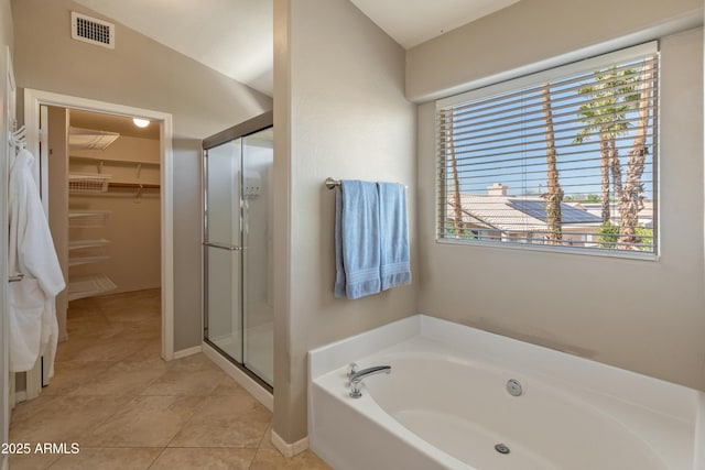full bath with tile patterned floors, a shower stall, a walk in closet, a bath, and visible vents
