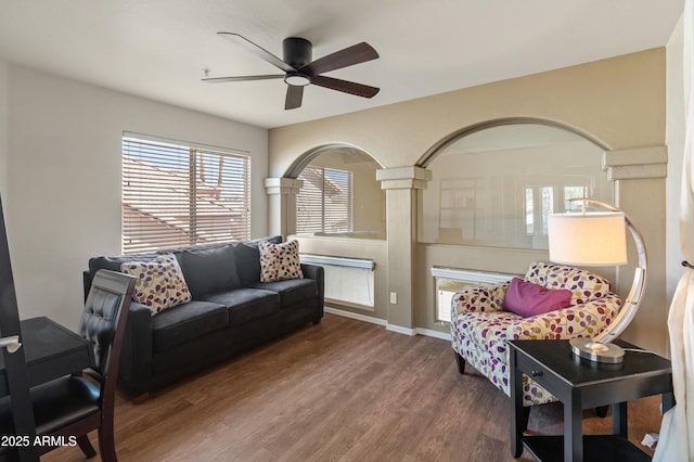 living room featuring a ceiling fan, baseboards, and wood finished floors