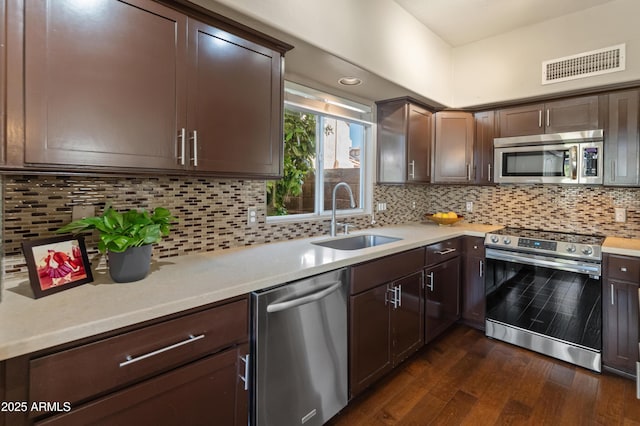 kitchen featuring light countertops, dark wood-type flooring, a sink, visible vents, and appliances with stainless steel finishes