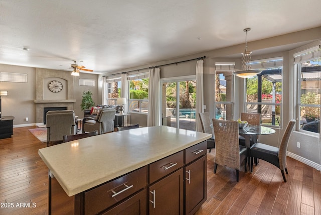 kitchen featuring baseboards, pendant lighting, ceiling fan, and hardwood / wood-style floors