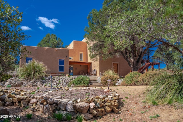view of front of home featuring stucco siding and stairs