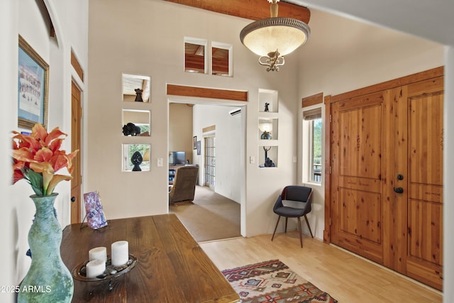 foyer with wood finished floors and a towering ceiling