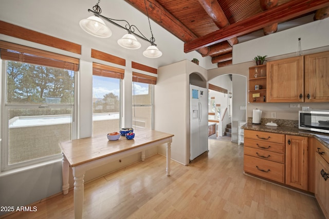 kitchen with open shelves, stainless steel microwave, arched walkways, beam ceiling, and wood ceiling