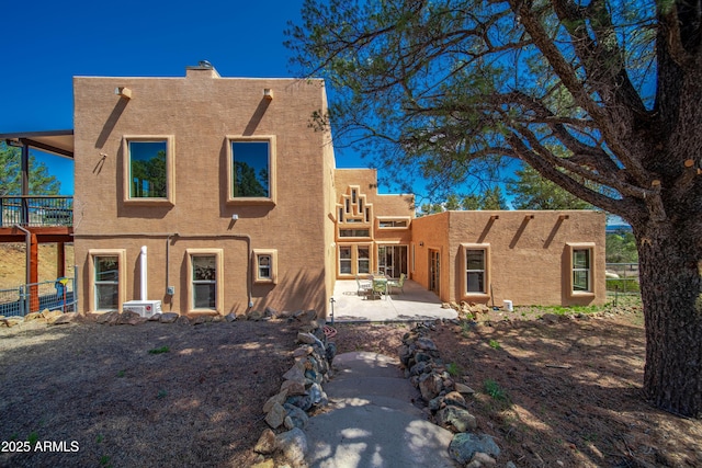 back of house featuring stucco siding, fence, and a patio area
