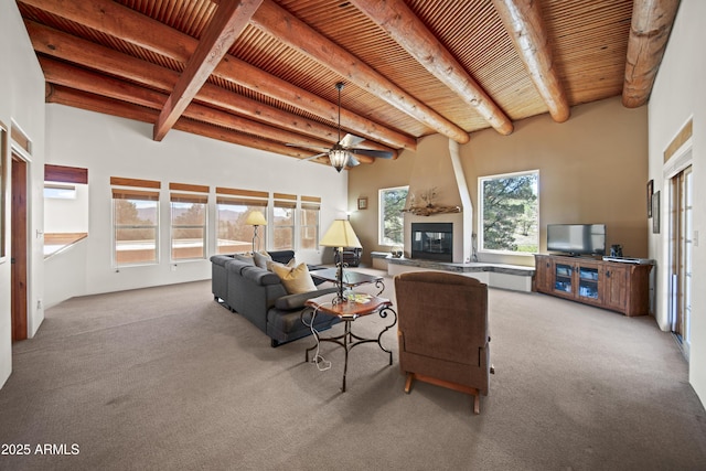 carpeted living area with wooden ceiling, a ceiling fan, beamed ceiling, and a fireplace