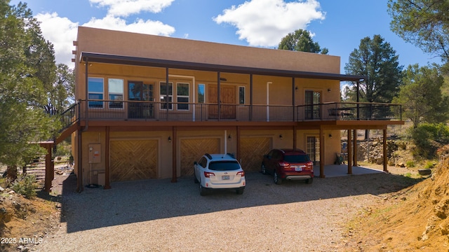 exterior space with stucco siding, an attached garage, and dirt driveway