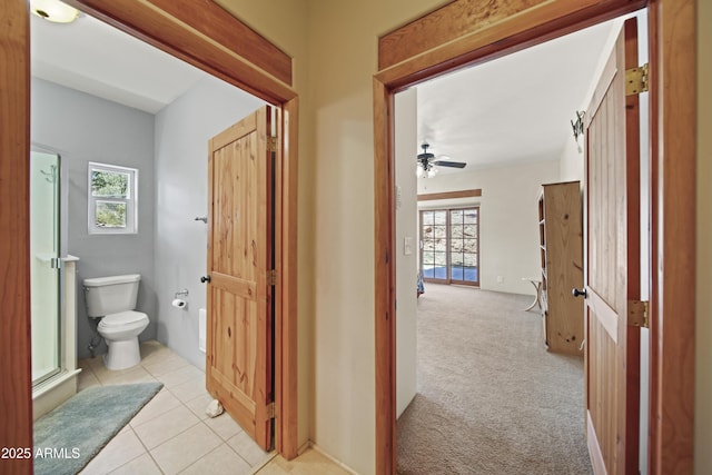corridor featuring light colored carpet and light tile patterned floors