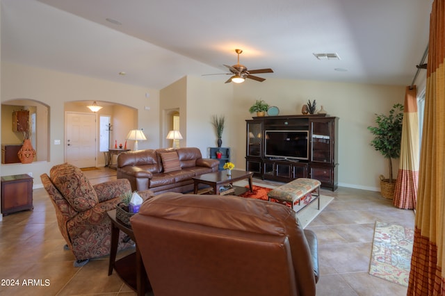 living room with lofted ceiling, ceiling fan, and light tile patterned floors