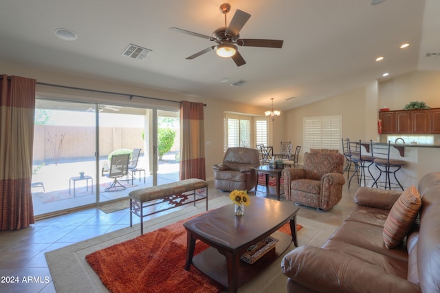 tiled living room with ceiling fan with notable chandelier and lofted ceiling