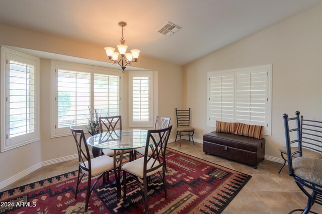 dining room with lofted ceiling, a chandelier, and light tile patterned flooring