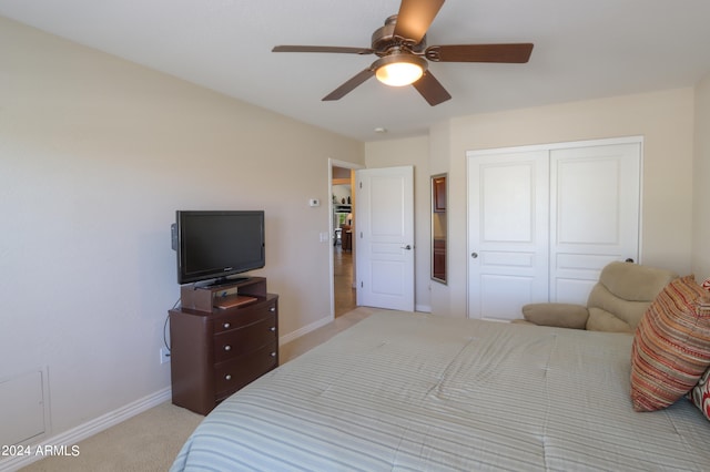 bedroom featuring a closet, ceiling fan, and light carpet