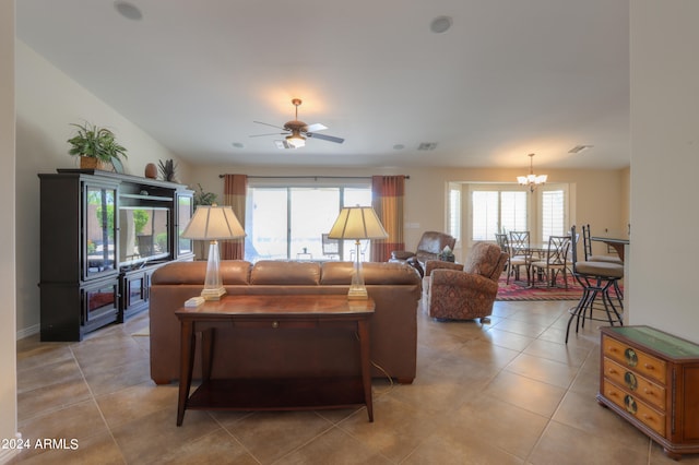 living room featuring ceiling fan with notable chandelier, plenty of natural light, and light tile patterned floors