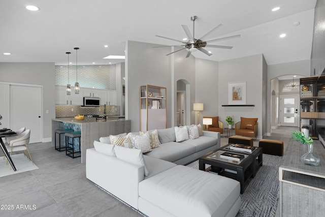 living room featuring ceiling fan and a towering ceiling