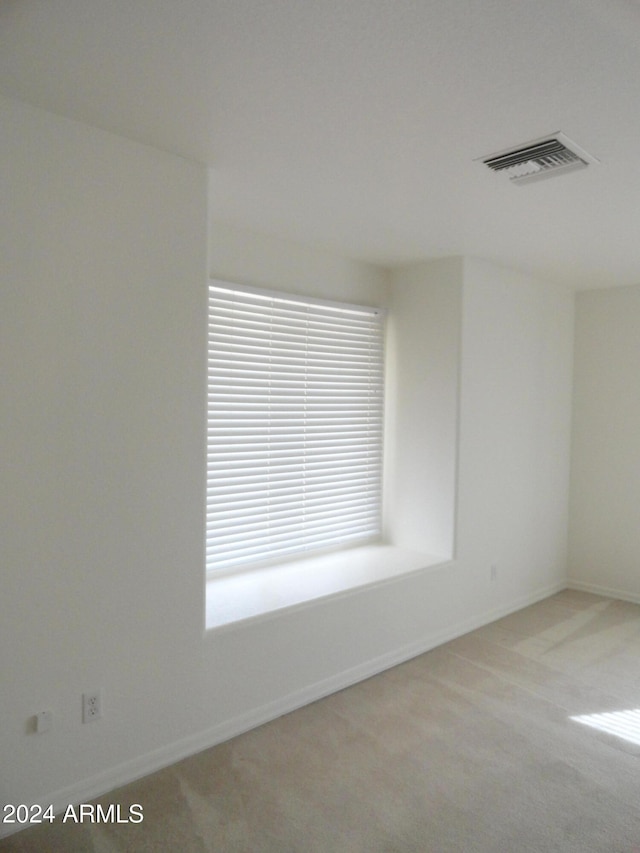 unfurnished room featuring light colored carpet