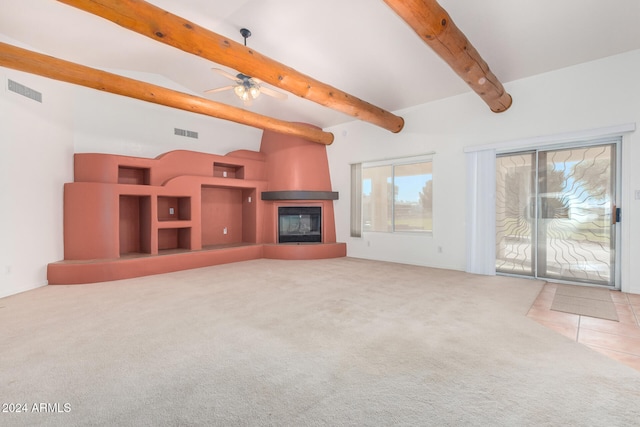 unfurnished living room with a fireplace, carpet, lofted ceiling with beams, and ceiling fan