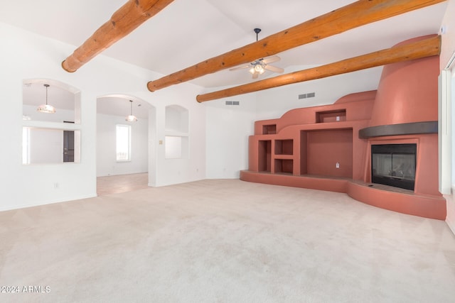 unfurnished living room featuring carpet flooring, a large fireplace, ceiling fan, high vaulted ceiling, and beamed ceiling