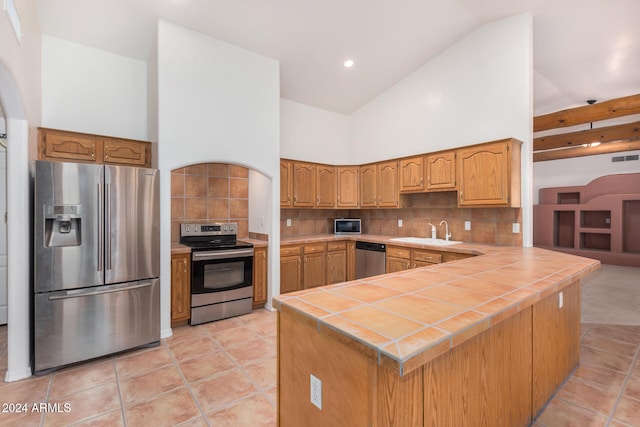 kitchen with kitchen peninsula, appliances with stainless steel finishes, backsplash, and sink