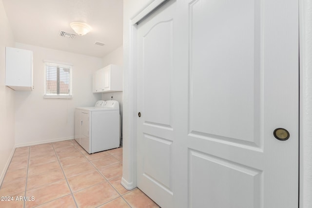 laundry room with cabinets, independent washer and dryer, and light tile patterned flooring