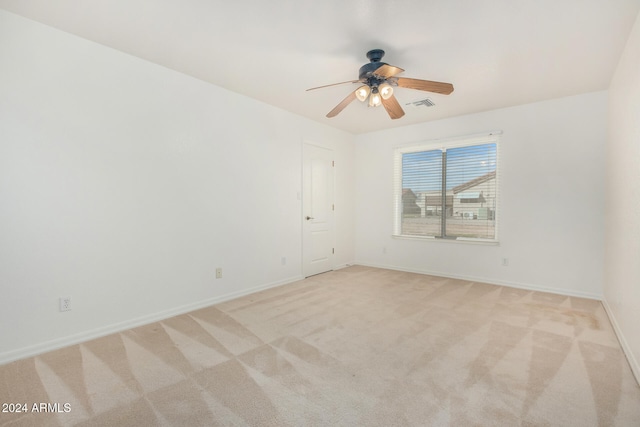 carpeted spare room featuring ceiling fan