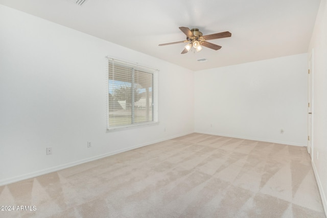 unfurnished room with light colored carpet and ceiling fan