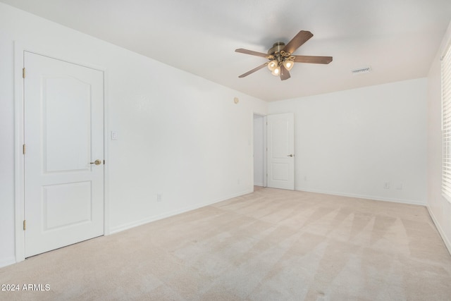 carpeted spare room with ceiling fan