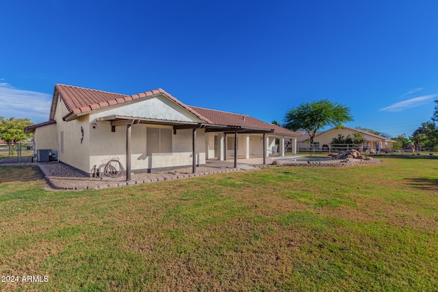 rear view of property featuring a yard, a patio, and central AC unit