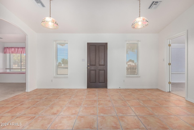 tiled spare room featuring lofted ceiling