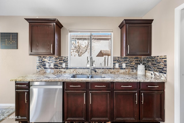 kitchen featuring light stone counters, a sink, decorative backsplash, and stainless steel dishwasher