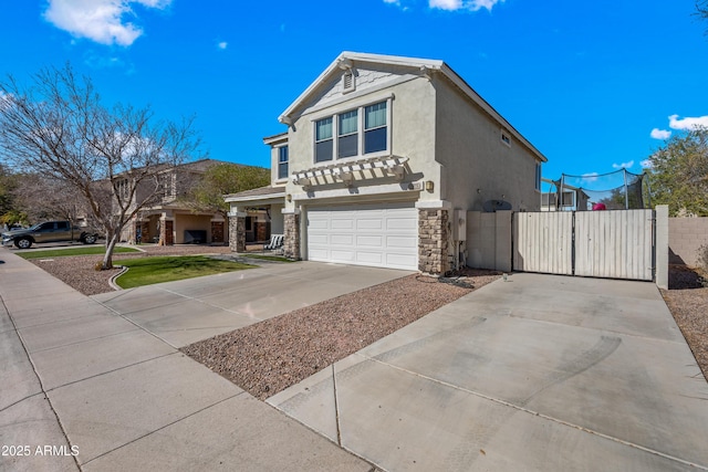 view of front of house featuring an attached garage, stone siding, driveway, a gate, and stucco siding