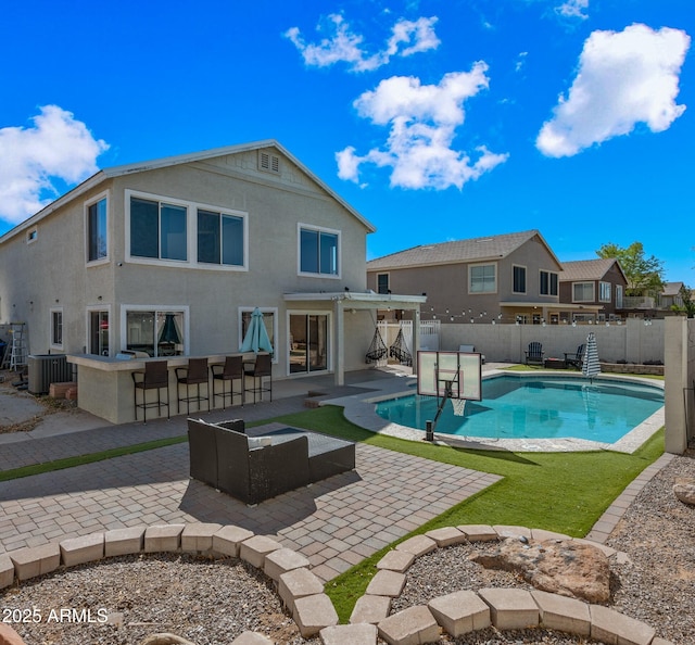 back of house featuring a fenced in pool, a fenced backyard, outdoor dry bar, central AC, and stucco siding